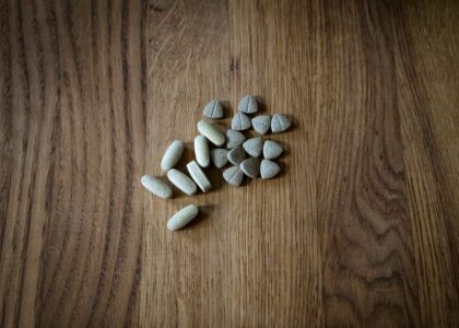 Assorted dog joint care supplement tablets and chews arranged on a wooden surface, illustrating options for canine joint health support.