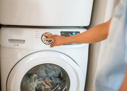 Person adjusting washing machine settings while cleaning reusable pee pads, illustrating proper washing steps for dog owners