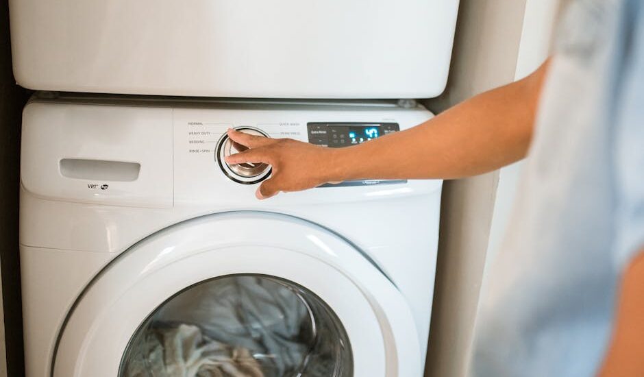 Person adjusting washing machine settings while cleaning reusable pee pads, illustrating proper washing steps for dog owners