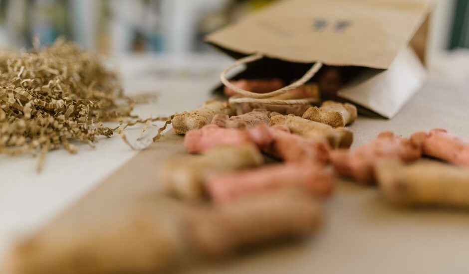 A variety of dog training treats spilling from a paper bag, related to training treat bags.